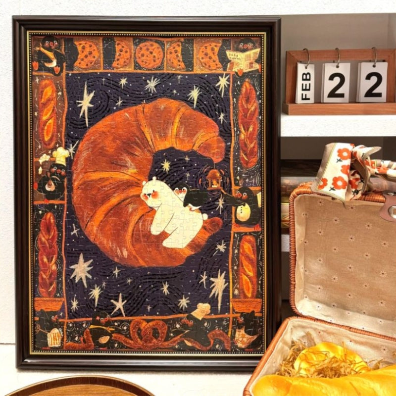 Completed Sweet Dream 520 piece jigsaw puzzle framed, showing croissant, penguins, pastries, and starry night design.
