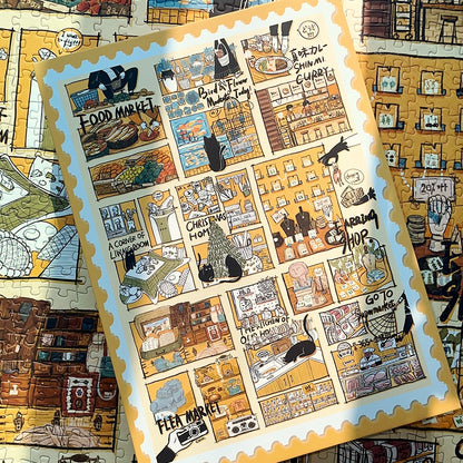 Puzzle pieces with a postcard-sized image of the Black Cat’s Diary artwork placed on the completed puzzle.