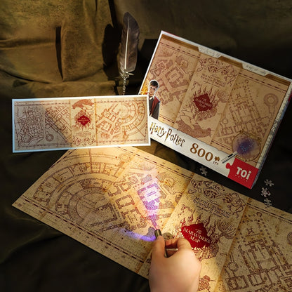 Harry Potter Marauder’s Map 800-piece puzzle by TOI, with glowing UV light effect and map design shown under torchlight.