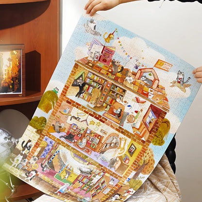 Person holding up the completed puzzle of The Library of Purring Pages