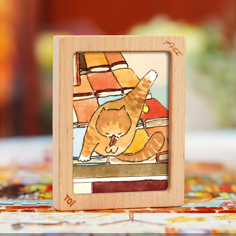Framed close-up detail of an orange cat on a rooftop of books