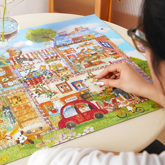 Person assembling the Café Paws & Whiskers puzzle on a round table.