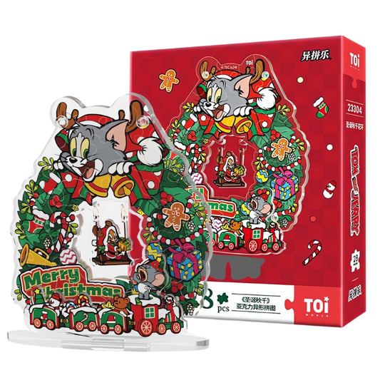 Tom and Jerry Christmas Swing Wreath acrylic puzzle displayed in front of the red TOI puzzle box with festive design.