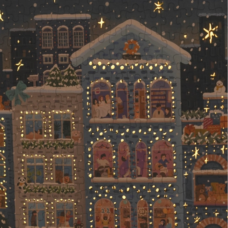 Puzzle detail showing foil accents on snowy night cityscape windows.