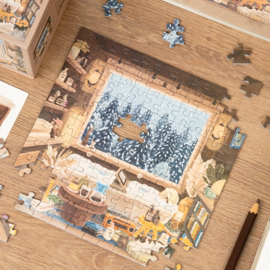 Partially assembled Snowy Cabin mini puzzle with pieces on a wooden table.