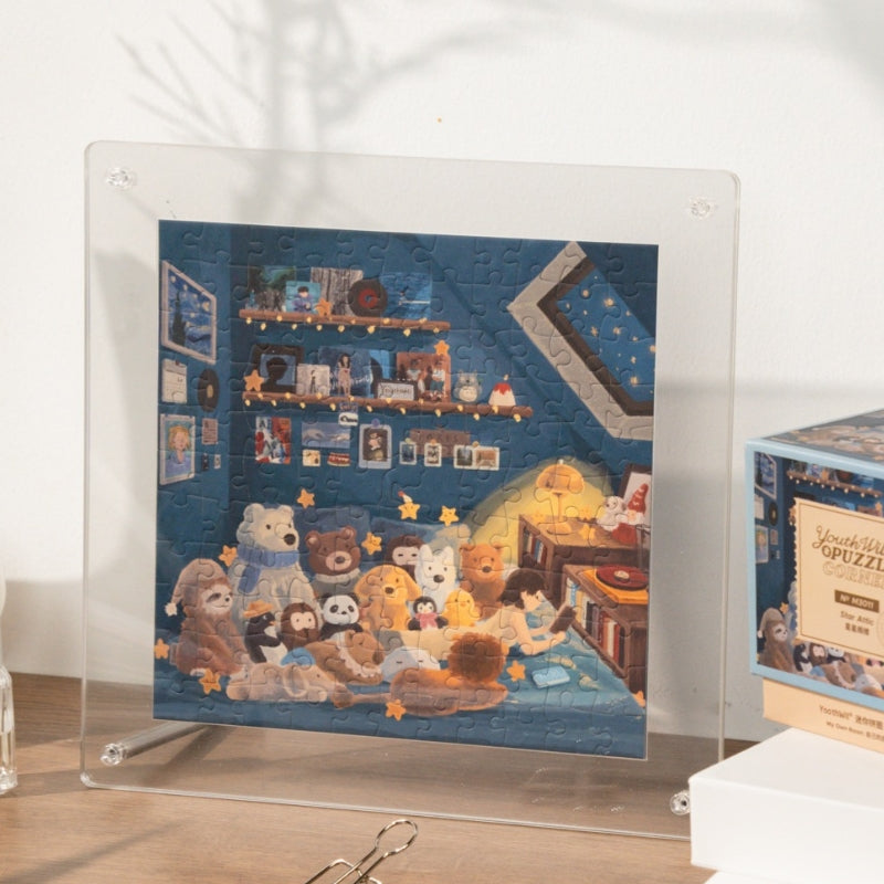 Completed Star Attic mini puzzle in acrylic display frame, showing attic scene with glowing stars and teddy bears.